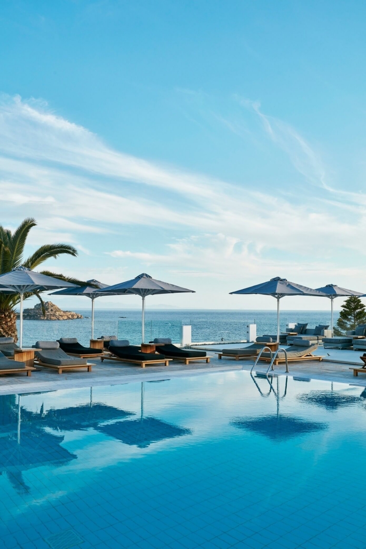 mobilier-luxe-hôtel-palace-piscine-extérieure-mobilier-bois-massif-parasols-vue