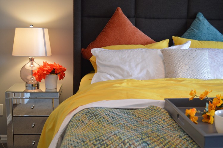chambre-cosy-tête-noire-coussins-décoratifs-multicolores-chevet-table-lampe