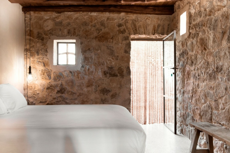 mur en pierre apparente -chambre-coucher-poutres-bois-apparentes-banc-bois-rustique