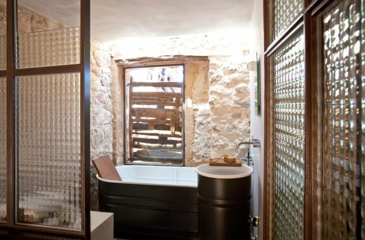 mur en pierre apparente -salle-bains-vasque-pied-baignoire-noir-blanc