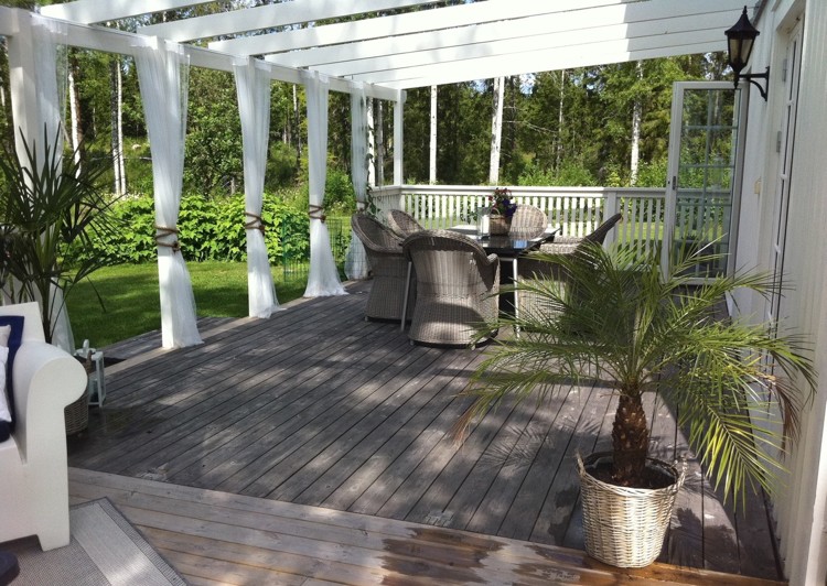 pergola avec rideaux -blancs-fauteuils-jardin-rotin-terrasse-bois