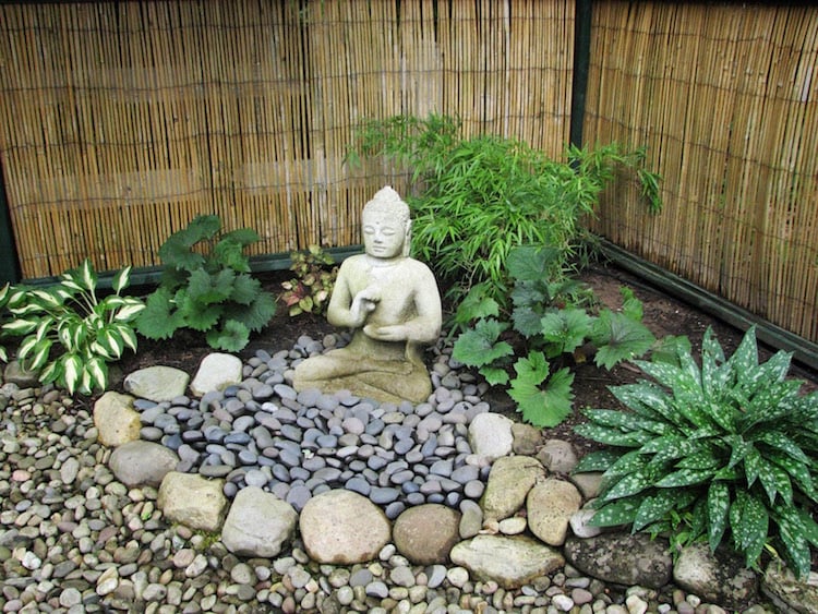 statue-jardin-zen-Bouddha-pierre-blanche-entourée-galets
