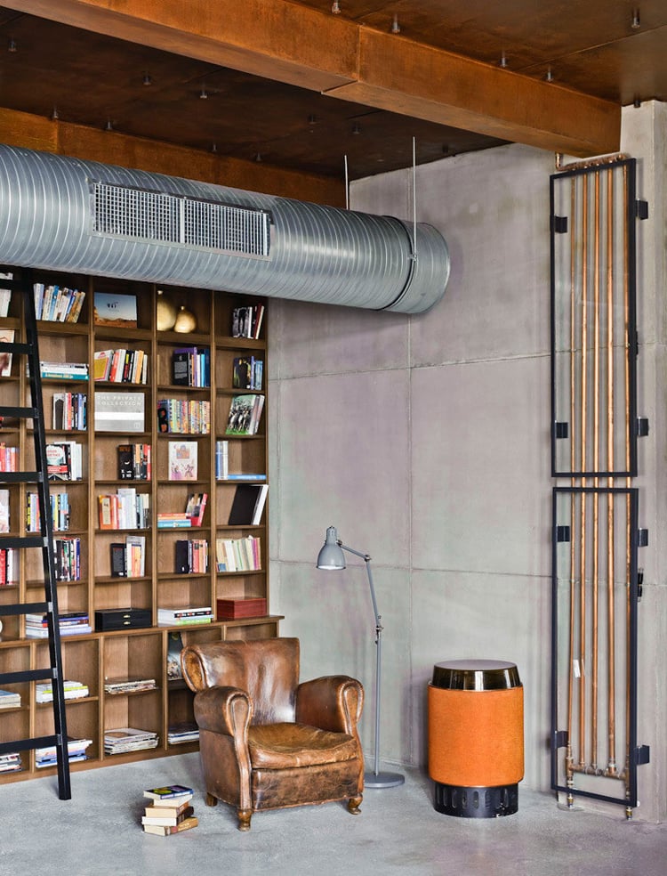 décoration industrielle -coin-lecture-fauteuil-club-cuir-marron-déco-murale-béton-bibliothèque-bois-tuyau-apparent
