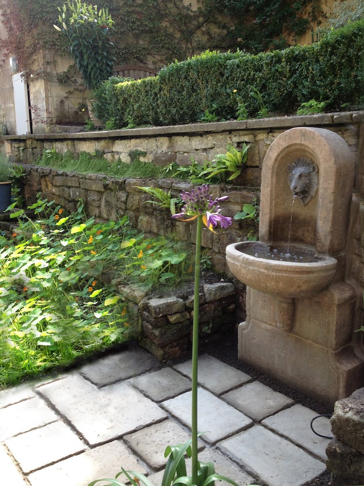 fontaine murale de jardin en pierre naturelle-tête-lion-plantes
