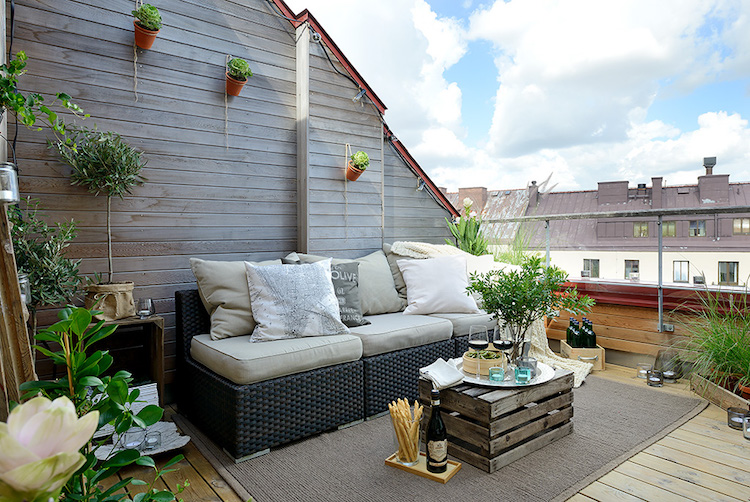 aménagement toit terrasse -canapé-résine-tressée-tapis-extérieur-table-basse-bois-déco-plantes-vertes