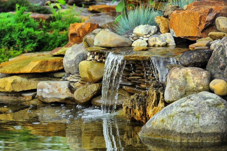 cascade bassin de jardin en rochers, terrasse en bois composite et mobilier  de jardin assorti