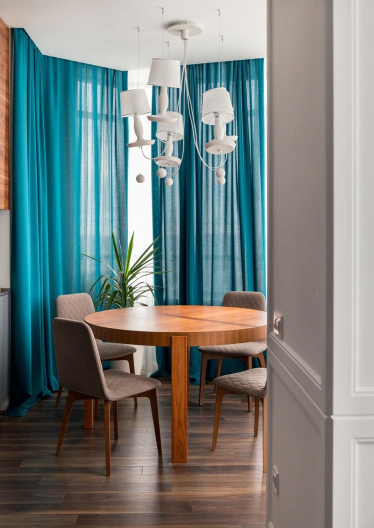 salle-manger-chic rideau bleu vert table-ronde-bois-lustre-design-blanc