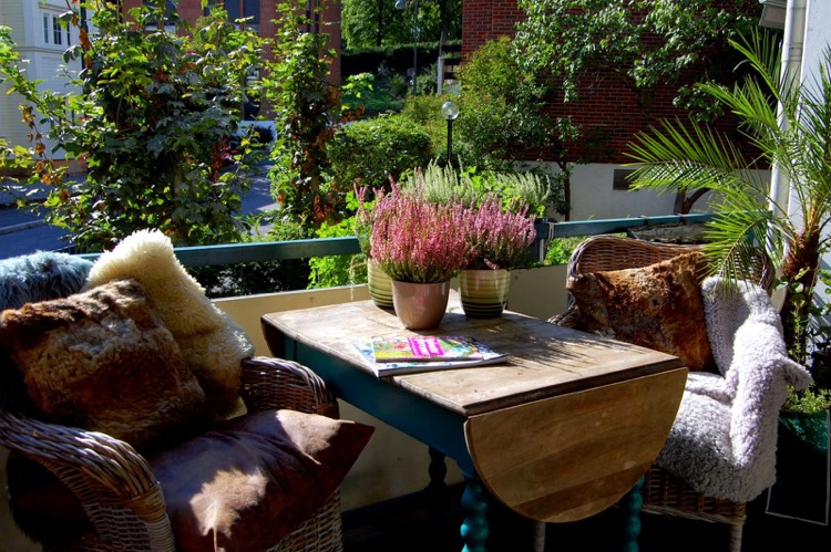 décoration balcon automne-bruyère-erica-coussins-couvertures-table-bois-massif-fauteuils-osier