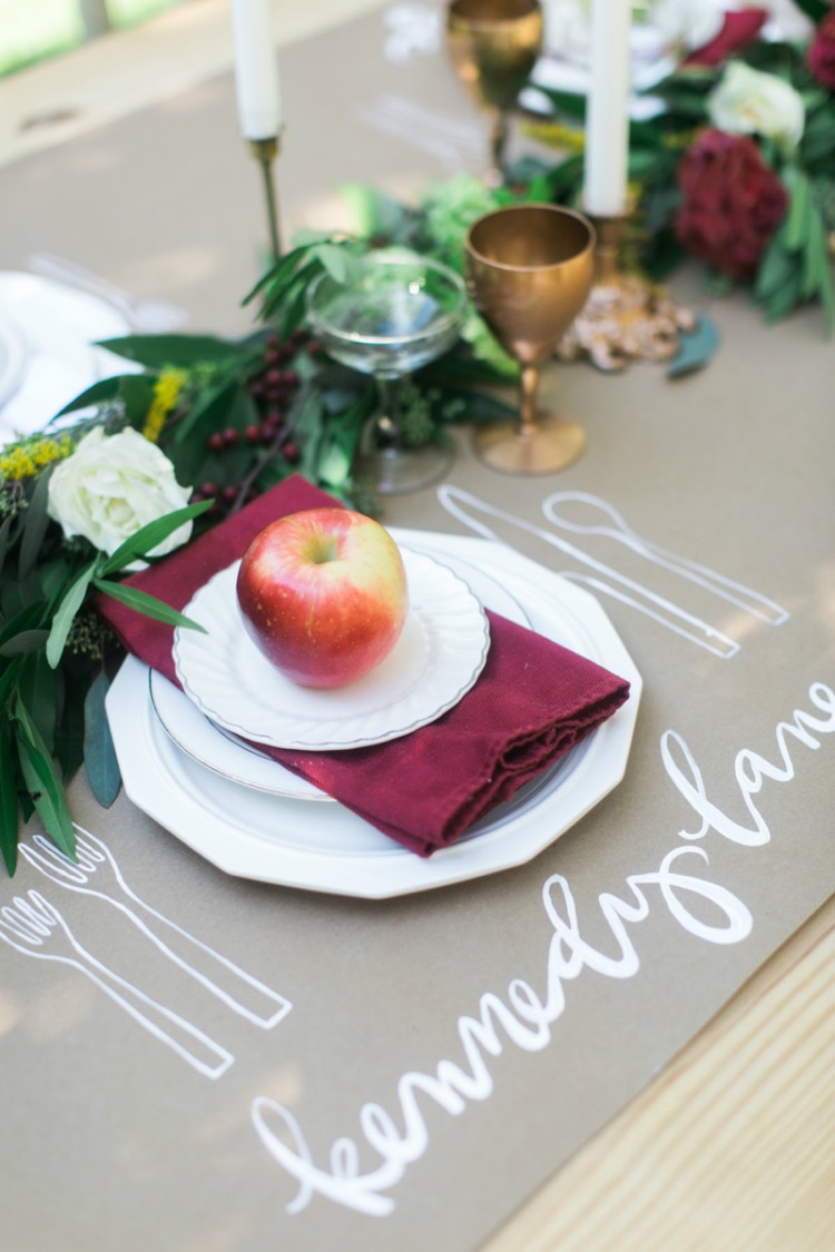 dressage de table -fête-déco-pomme-serviette-tissu-rouge-guirlande-feuilles-roses-baies-rouges