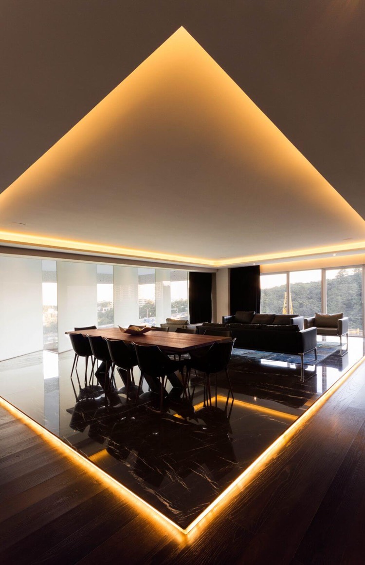salle à manger design contemporain-carrelage-marbre-noir-corniche-lumineuse-table-bois-massif-chaises-noires