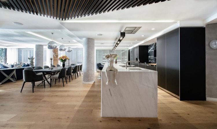 salle à manger design contemporain-table-rectangulaire-chaises-tapissées-parquet-bois-îlot-cuisine-marbre-blanc