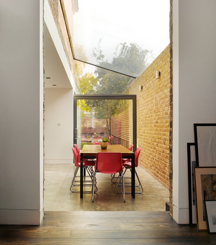 extension-maison-toit-verre-meubles-modernes-chaises-rouges