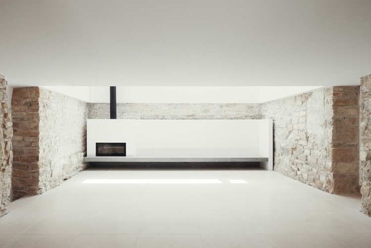 mur-de-pierre-naturelle-salle-sejour-minimaliste-cheminee-banquette-beton