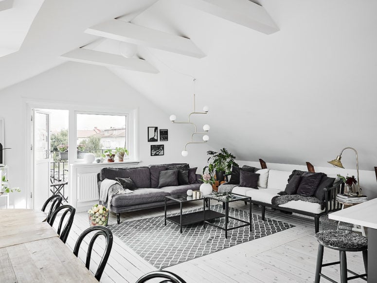 interieur-scandinave-blanc-canape-gris-table-basse-noire-tapis-scandinave-gris-plancher-bois-blanchi