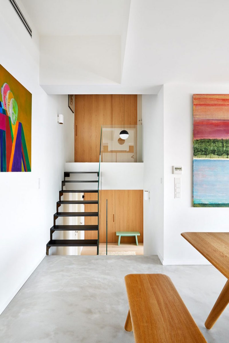 armoires-couloir portes en bois tableaux-multicolores-peinture-murale-blanche