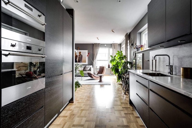 cuisine-moderne-armoires-noires-parquet-clair-peinture-grise-fond