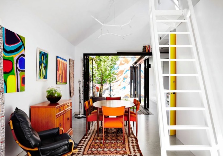decoration-boheme-salle-manger-chaises-orange-tableaux-couleurs-vives-chaise-relax-cuir-noir