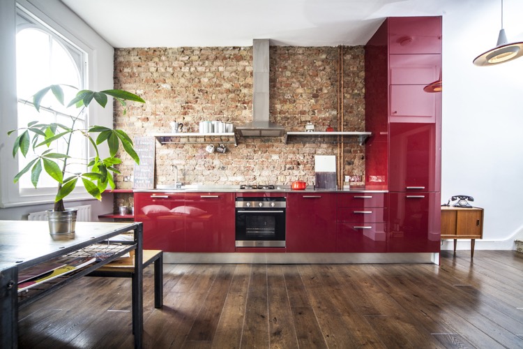 idee-deco-cuisine-moderne-rouge-laque-mur-brique-exposee-plancher-bois