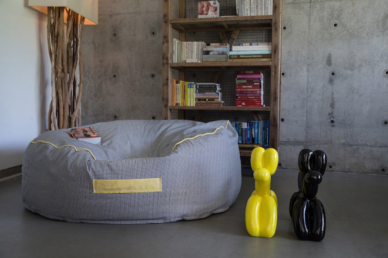 pouf géant rond parfaitement assorti au fond frais en béton gris pouf-geant-avec-poignee-sol-murs-beton-lampdaire-pied-bois-flotte