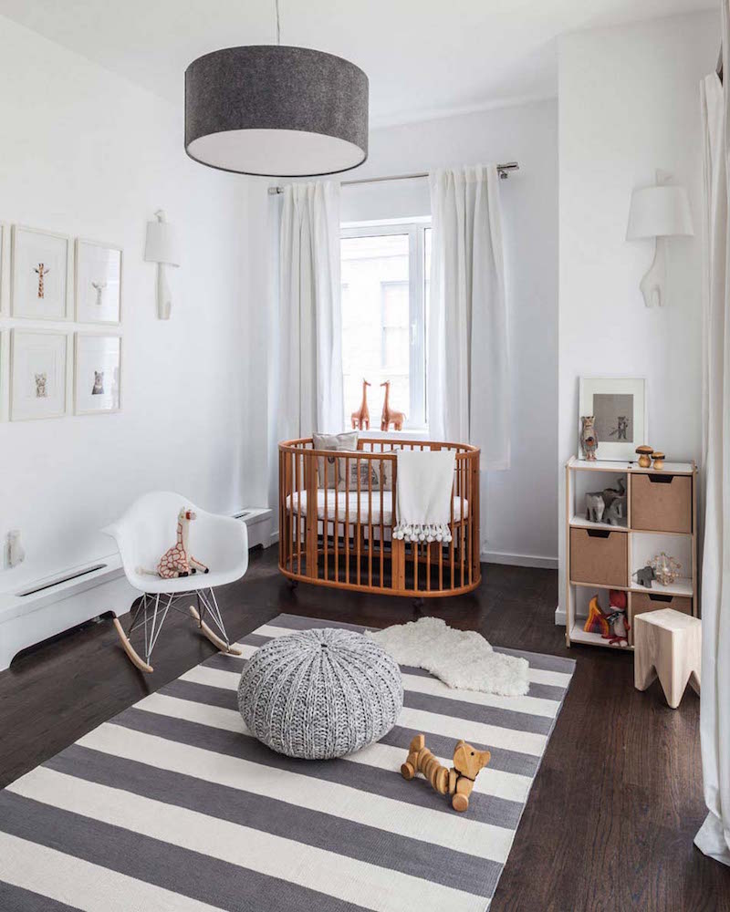 chambre de bébé décorée à la scandinave en blanc, bois naturel et gris perle pouf-tricot-gris-fauteuil-bascule-eames-lit-bebe-bois-tapis-raye