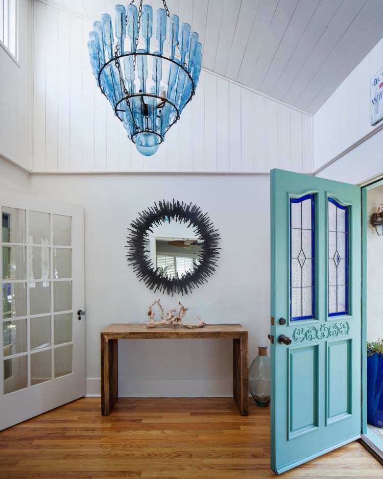 idee-deco-entree-maison-porte-entree-bleue-miroir-soleil-console-bois-lustre-bouteilles