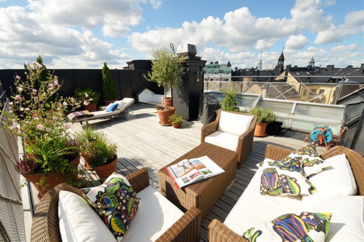 salon de jardin tressé, déco en coussins et plantes en pots sur le toit-terrasse deco terrasse appartement-salon-jardin-tressé-déco-plantes-vertes