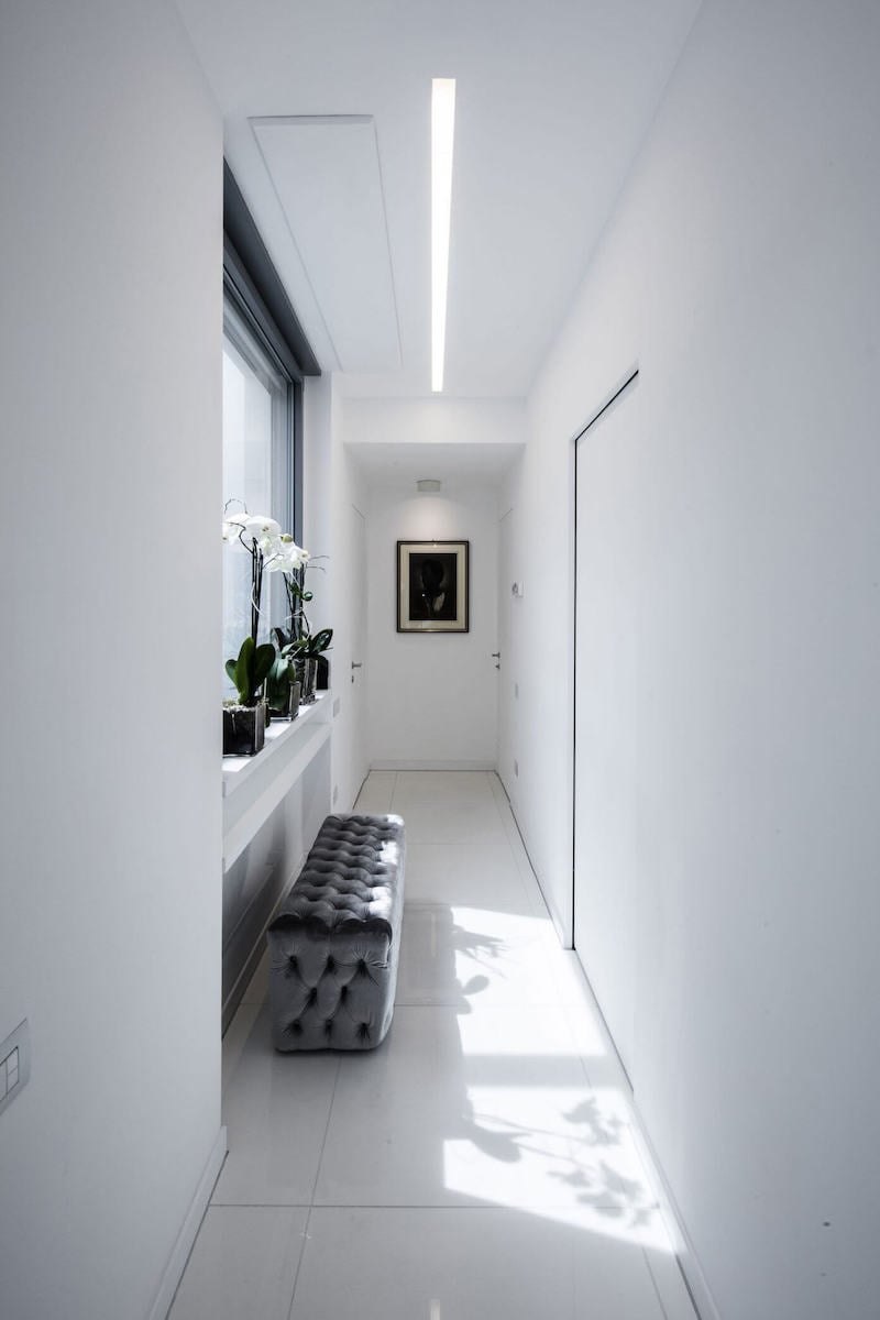 intérieur-maison-moderne-couloir-blanc-banc-capitonné-orchidées