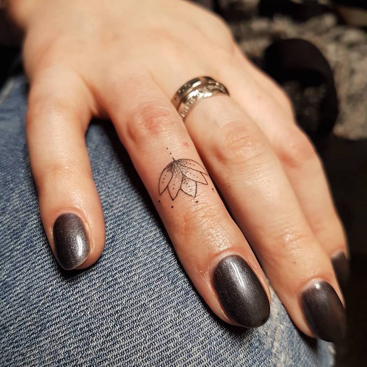 tatouage-doigt-annulaire-fleur-lotus-minimaliste