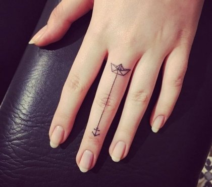 tatouage-doigt-femme-bateau-papier-ancre-stylisé-majeur