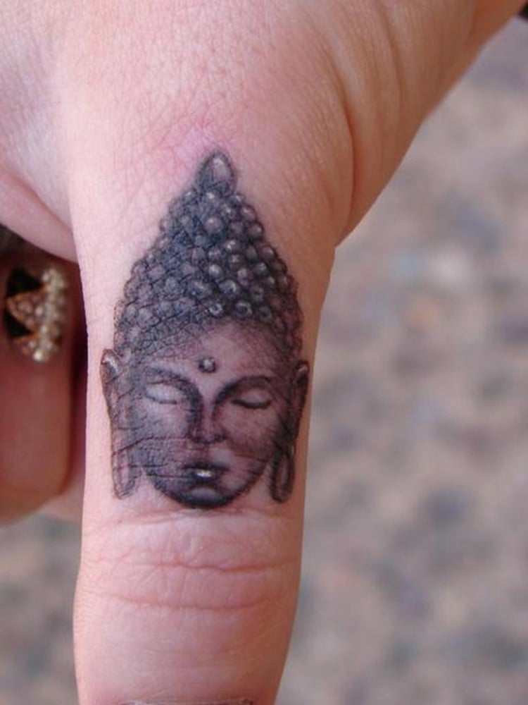 tatouage-doigt-femme-homme-tête-Bouddha-symbole-religieux