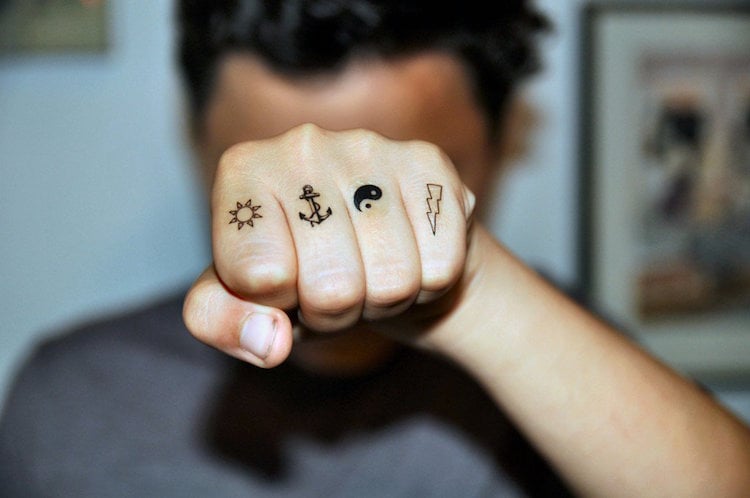 tatouage-doigt-homme-motif-soleil-ancre-éclair
