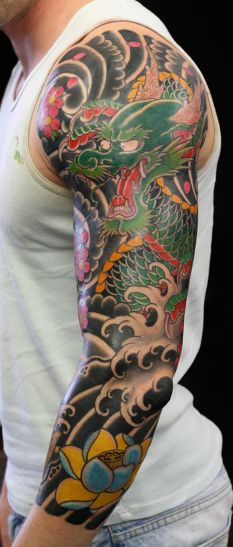 tatouage-bras-homme-japonais-dragon-vagues-fleurs