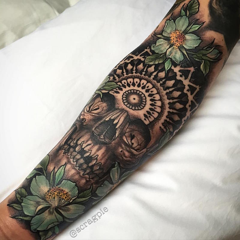 tatouage-bras-homme-noir-gris-vert-tête-de-mort-fleurs