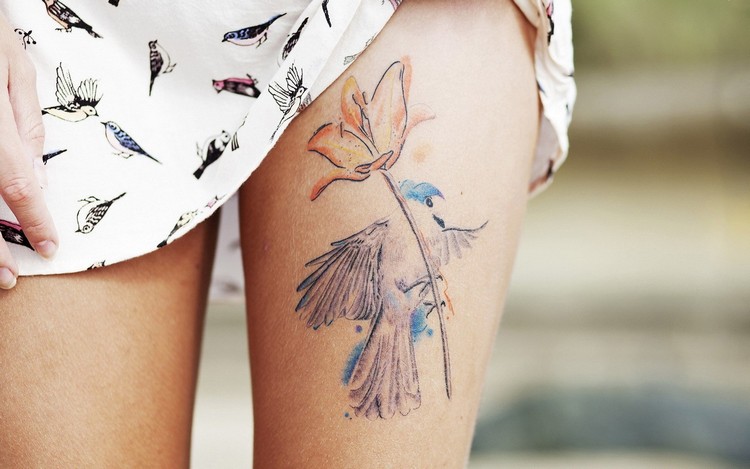 tatouage-fleur-de-lys-aquarelle-cuisse-oiseau-coloré