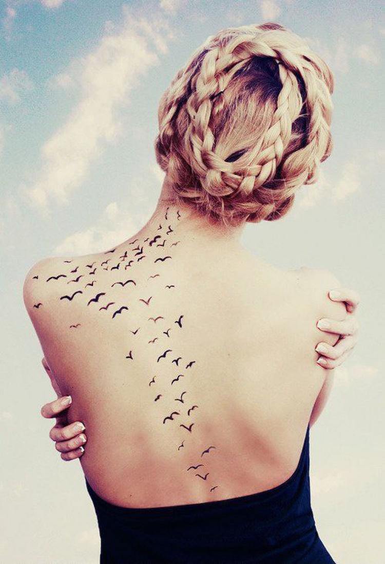 tatouage-oiseau-envolee-oiseaux-silhouettes-dos-femme