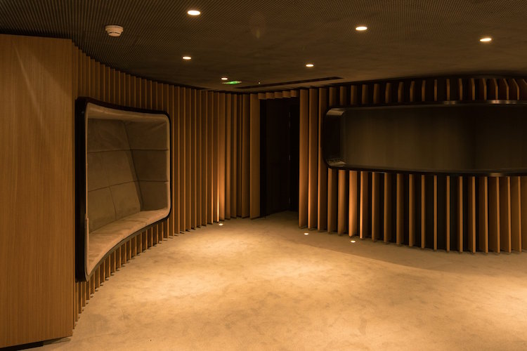 escalier colimacon bois panneaux empiles verticalement espace réception bâtiment bureaux paris