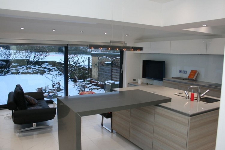 extension maison en parpaing optimisation espace cuisine avec îlot style épuré peint blanc