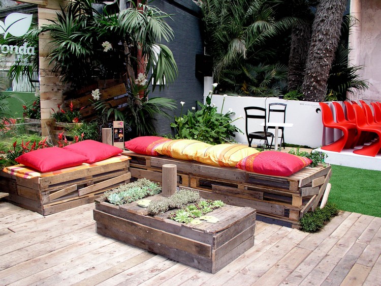 salon de jardin en palette table très créative et deux canapés avec des coussins colorés