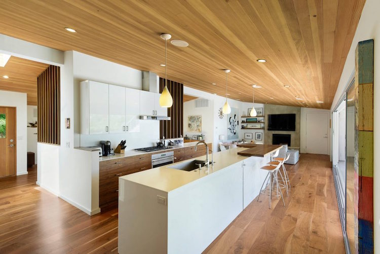 cuisine moderne avec ilot blanc espace repas plafond bois