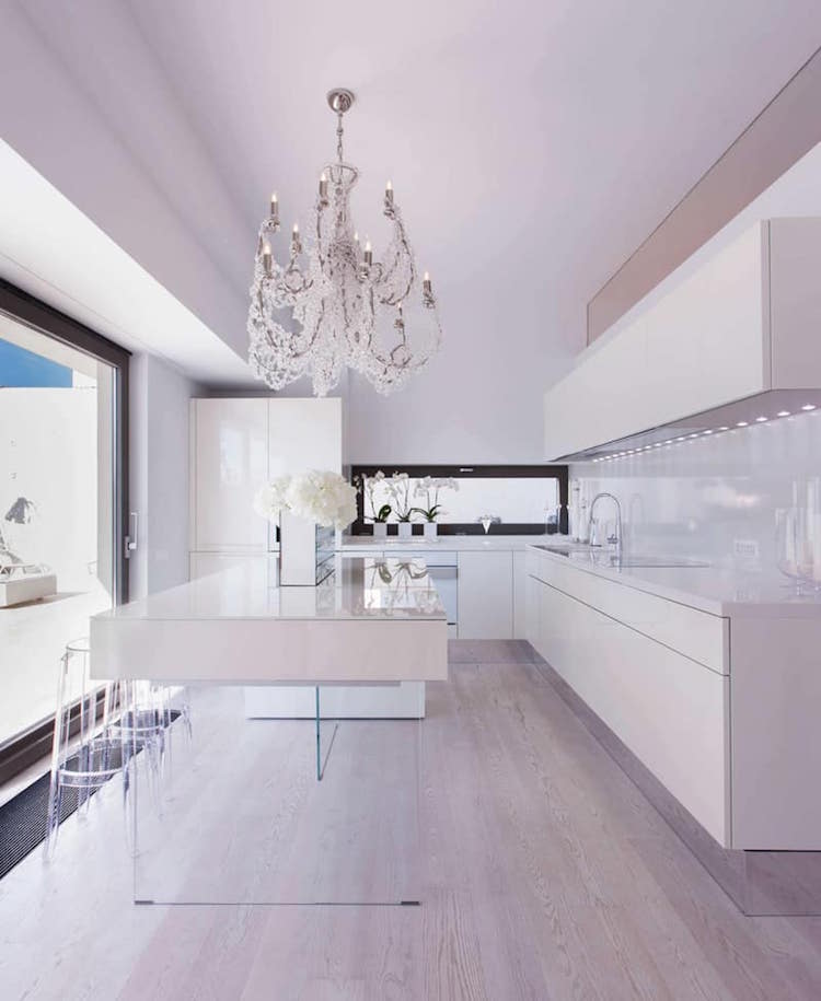 cuisine moderne avec ilot central blanc pieds verre transparent style minimaliste