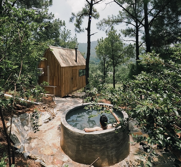 façade vitrée petite cabane en pleine nature Vietnam design bois cuve thermale extérieure