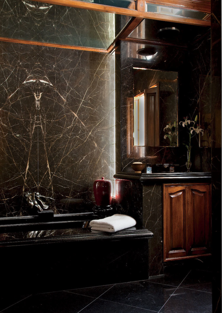 revêtement mural en marbre noir et meubles en bois salle de bains