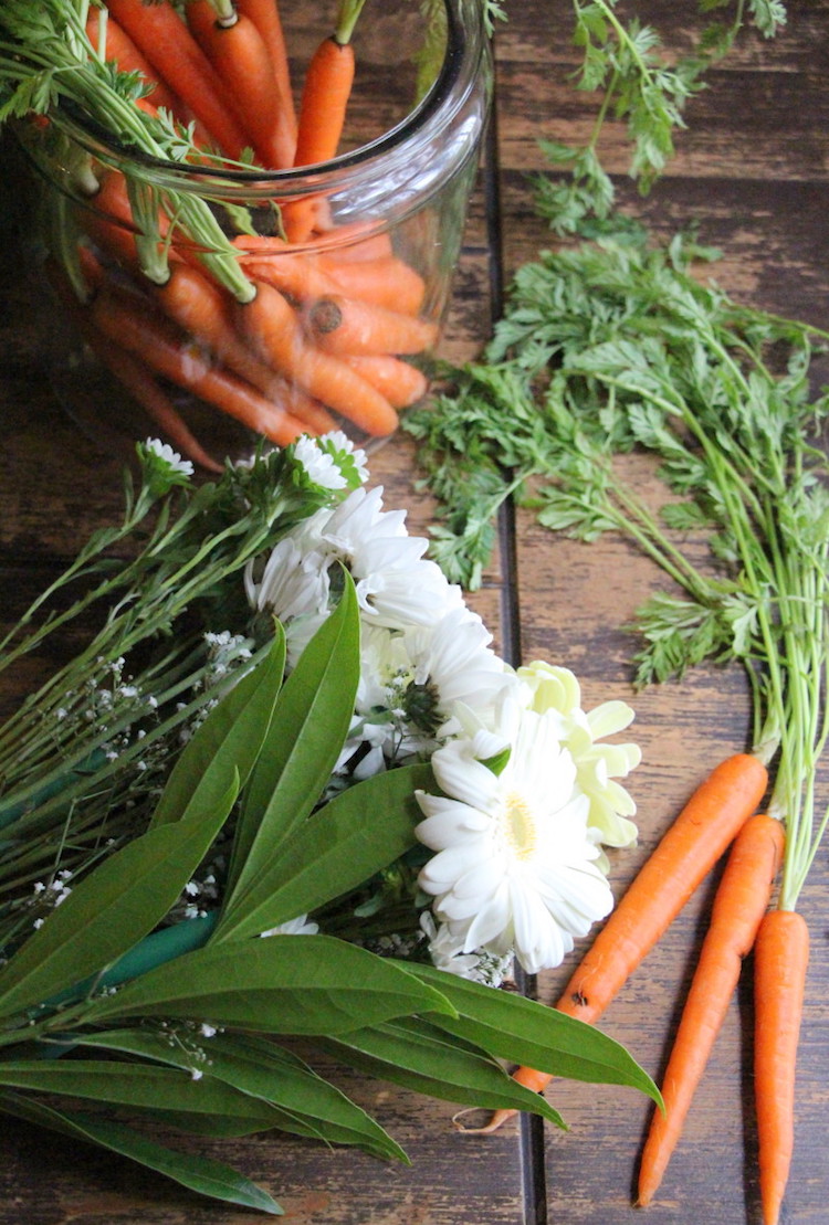 centre de table Paques en carottes avec la verdure et fleurs blanches