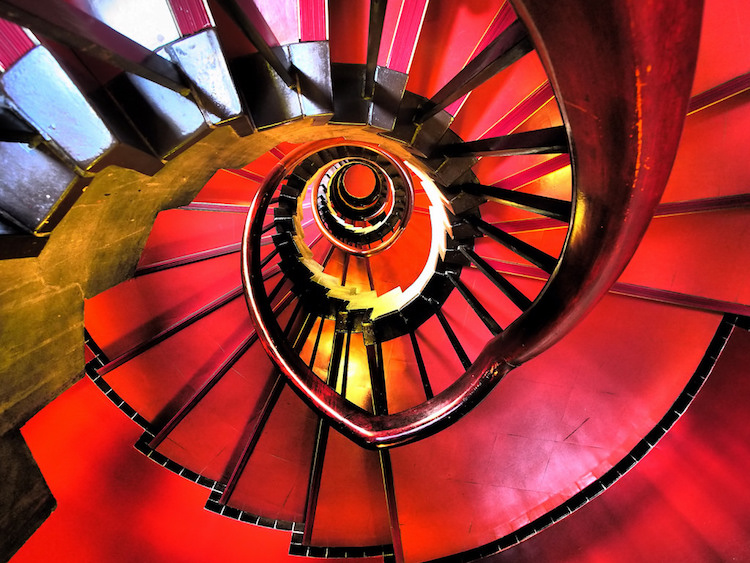 escalier spirale en rouge intense avec rambarde en bois