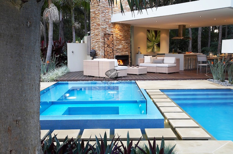 piscine transparente exclusive terrasse bois cheminee pierre salon jardin rotin