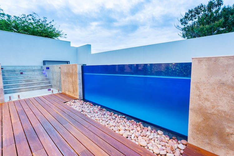 piscine transparente paroi verre deco galets terrasse bois