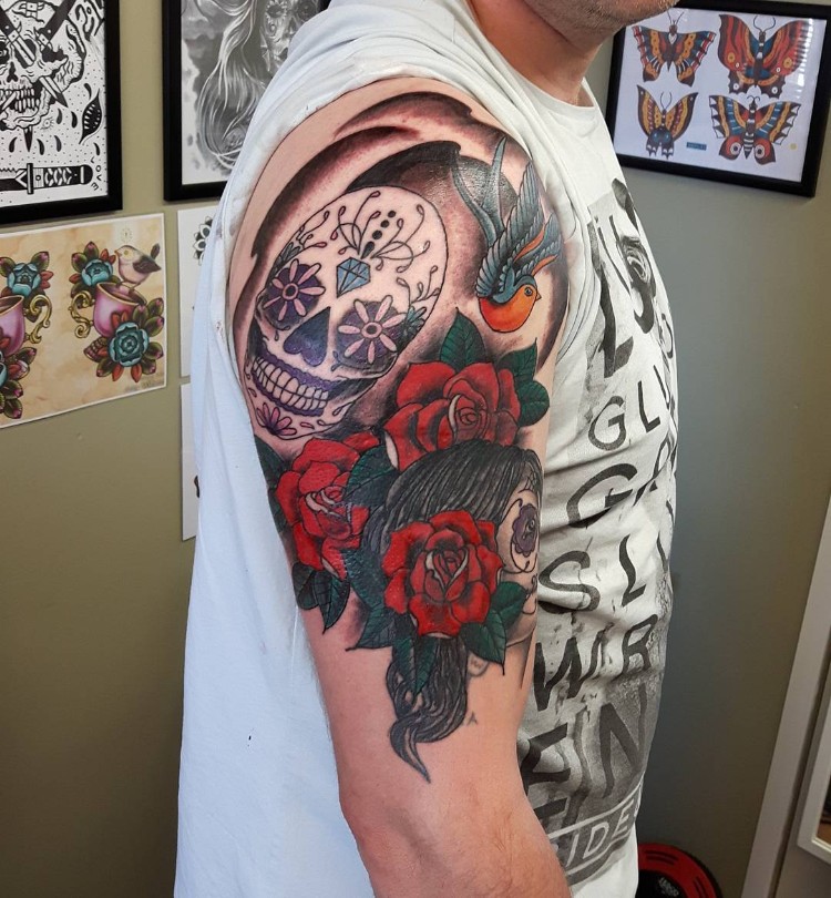 tatouage homme bras motifs colorés roses tête mort