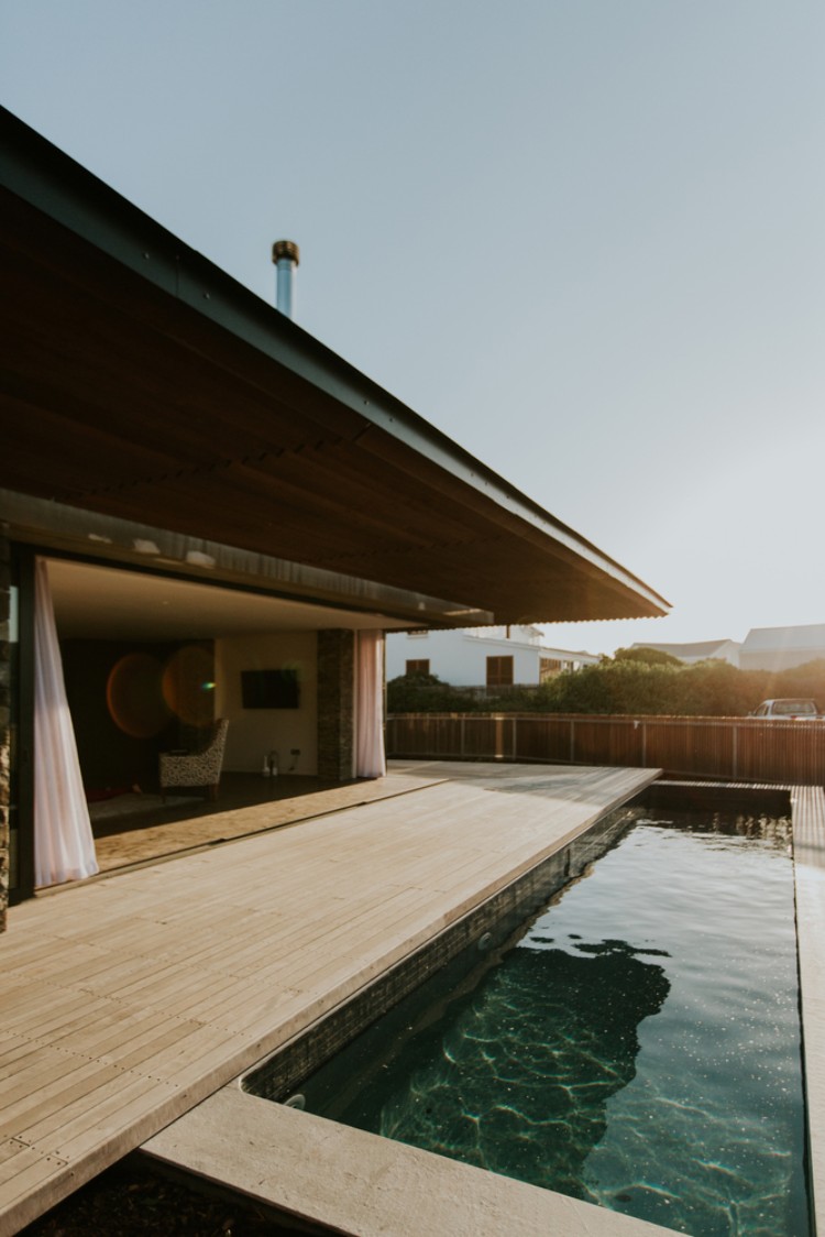 mur en pierre apparente extérieur terrasse bois avec piscine hors sol maison architecte contemporaine luxe
