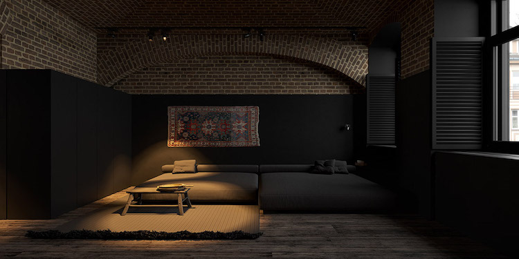 appartement sombre mur demi peint noir brique exposee canape taupe