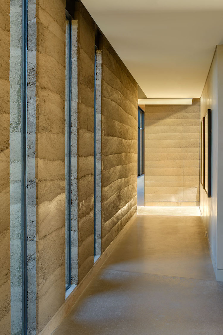 murs en pisé et sol en béton lissé couloir Kendle Design Collaborative